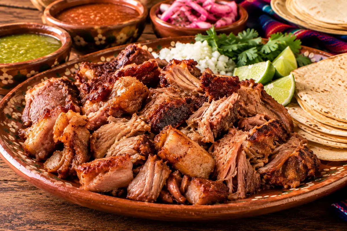 Carnitas doradas con tortillas y salsas